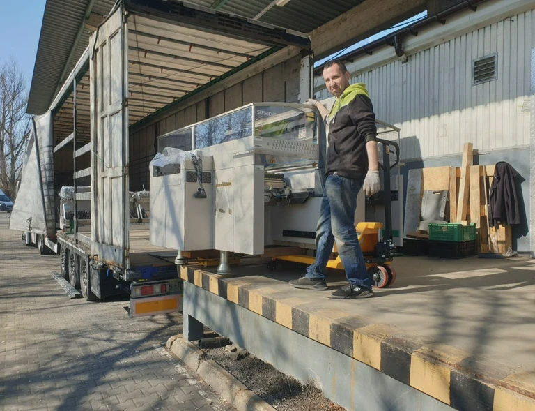 załadunek maszyny na&nbsp;ciężarówkę przez pracownika